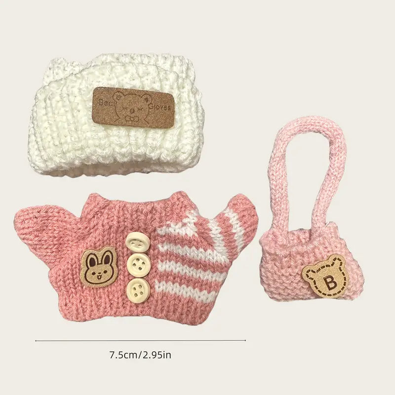 Set of knitted pet accessories including a pink outfit with buttons, a white pouch, and a pink bag on a light beige background at Zibuya Official store