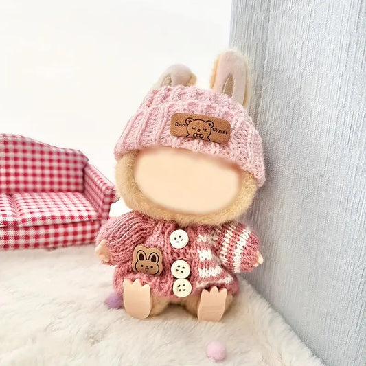 Stuffed toy with a pink knitted hat and coat on a soft surface | ZIbuya