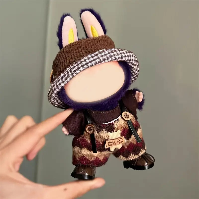Labubu Small plush toy with a checkered hat and outfit held by a hand against a plain background at Zibuya Official Store