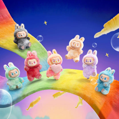 Zibuya - All seven plush pendant characters from The Monsters Big Into Energy series walking on a rainbow path in a dreamy fantasy setting