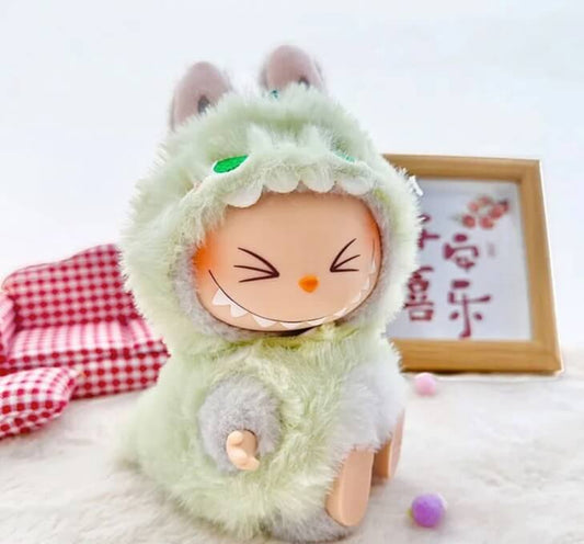 Plush toy with a cartoon face wearing a green outfit on a white background