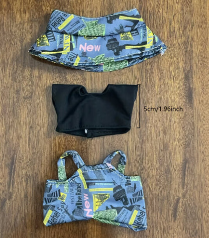 Flat lay of Zibuya’s Labubu doll clothing set, including a newspaper-print bucket hat, black cropped T-shirt, and matching overalls, designed for stylish collectible displays.
