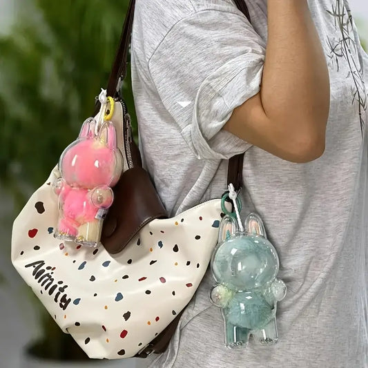  Zibuya Labubu dolls in clear acrylic protective cases, hanging on a bag as charms, featuring pink and mint fur designs for stylish, on-the-go display and protection.